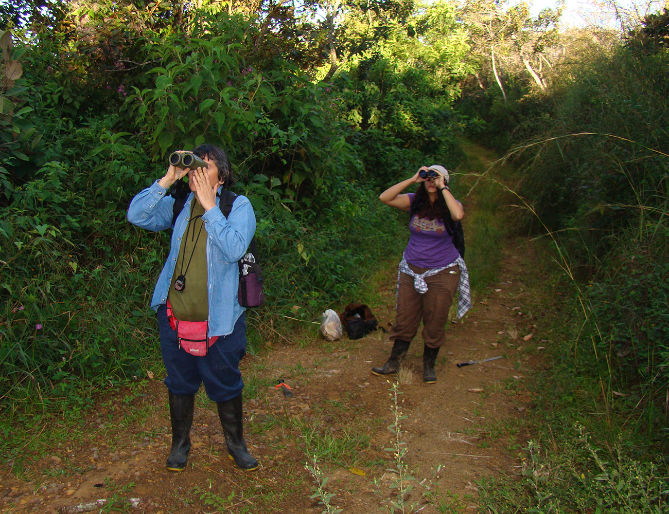 Las ornitólogas Ghisselle Alvarado (adelante) y Silvia Bolaños en investigación y observación de aves