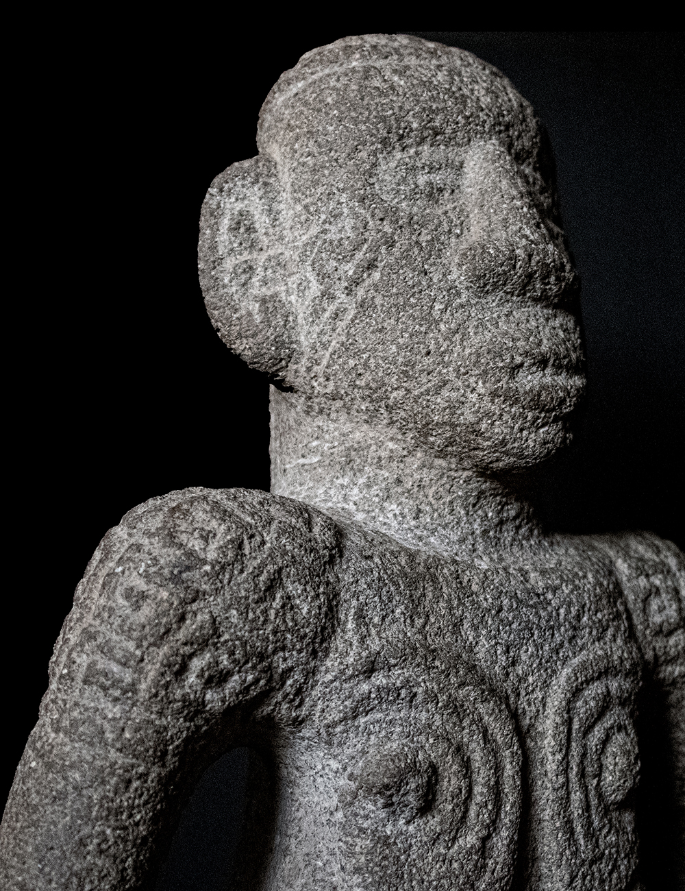 Detalle de una escultura en piedra con forma de guerrero